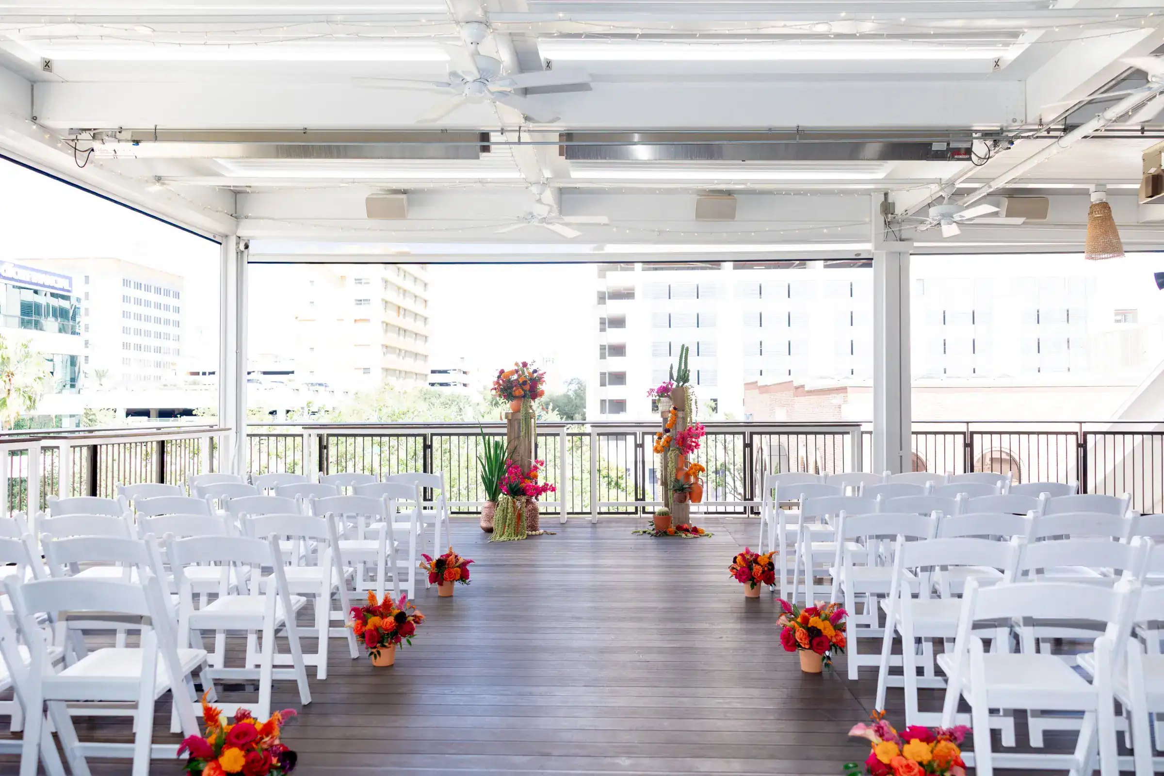 Downtown St. Pete Balcony Wedding Ceremony with White Folding Chairs at Red Mesa Events