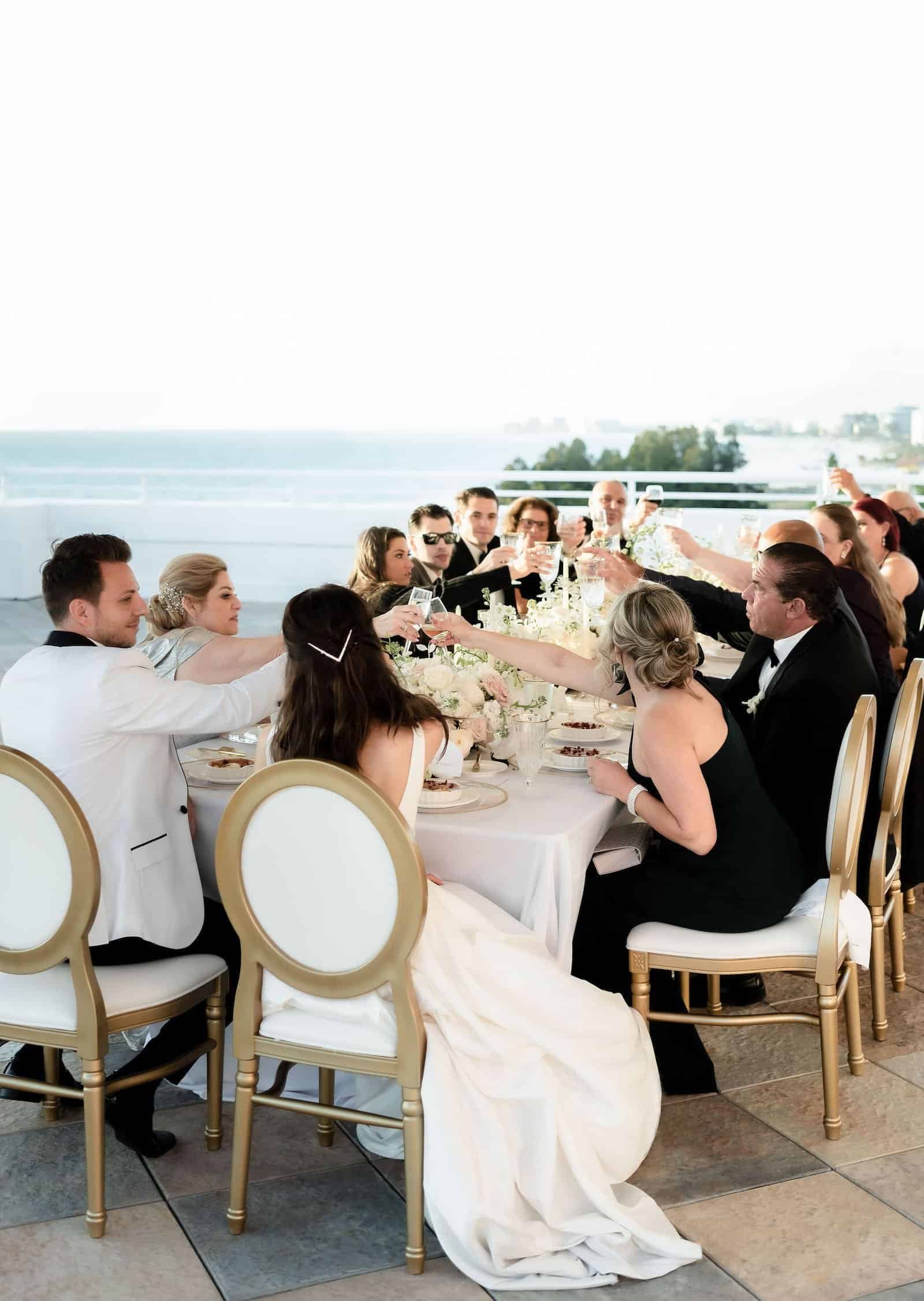 Romantic Red and White Winter Ballroom Reception at Wyndham Grand Clearwater Beach with Custom Ceiling Draping and Dramatic Chandelier Glow