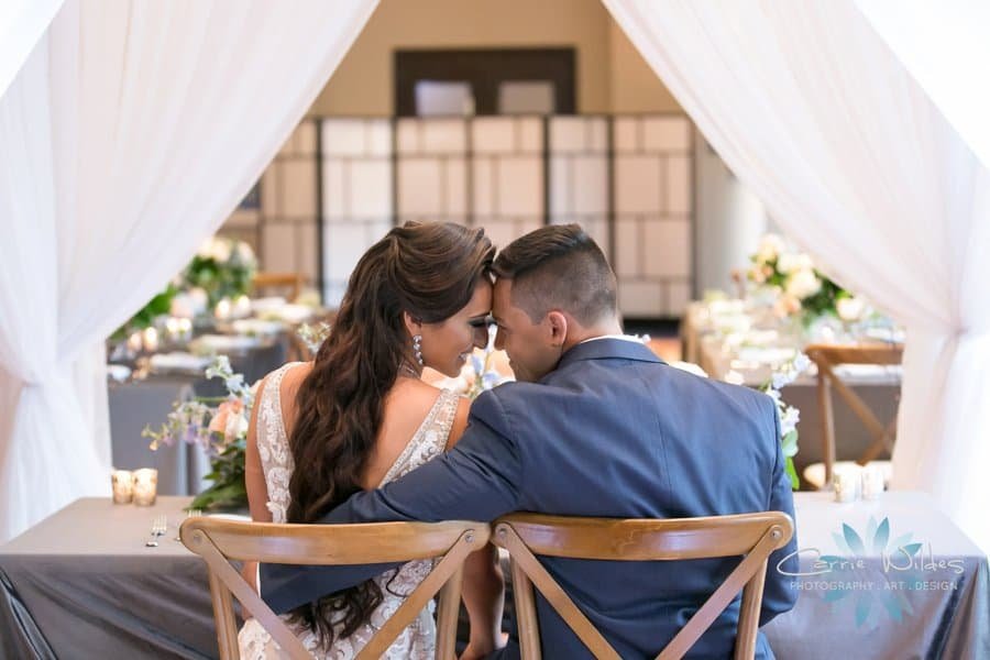 Intimate sweetheart table featuring rich velvet textiles, geometric gold accents, and lush floral installations
