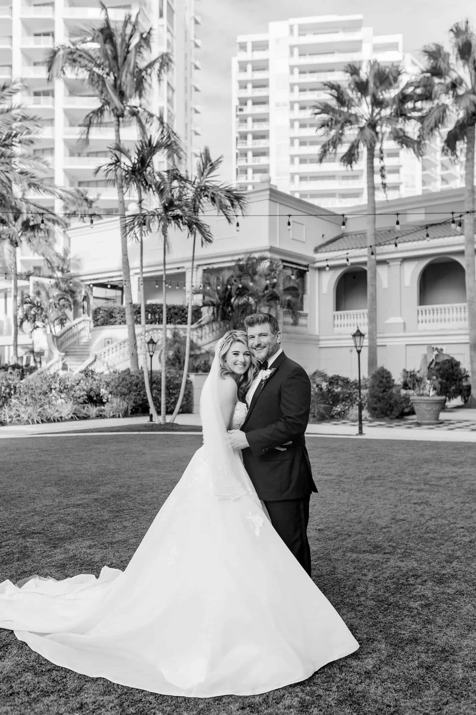 Luxury round reception feasting tables adorned with rich burgundy florals, velvet linens, and gold decor rentals at The Ritz-Carlton Sarasota