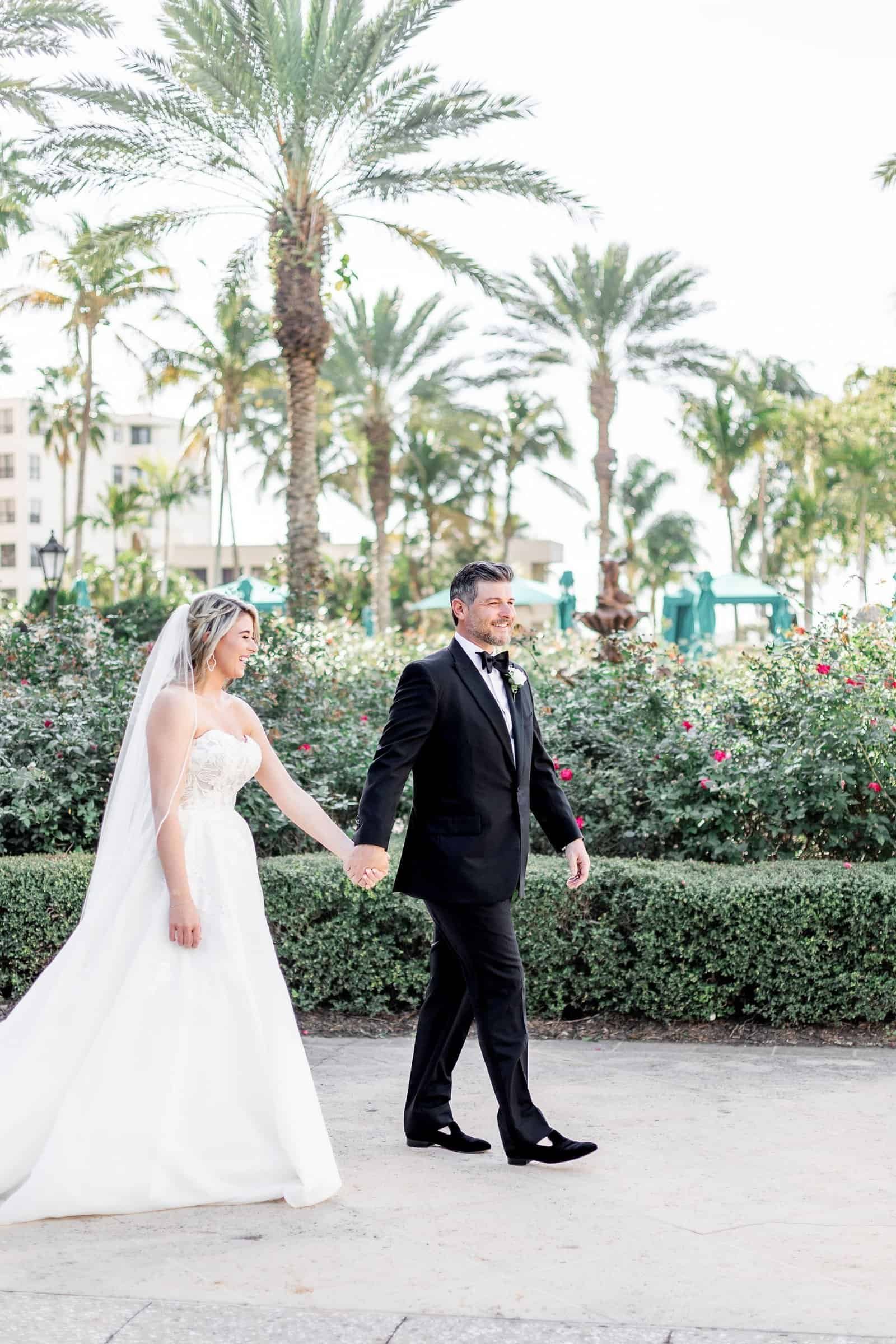 Bride in couture gown and groom in classic tuxedo sharing their first dance surrounded by guests at The Ritz-Carlton Sarasota