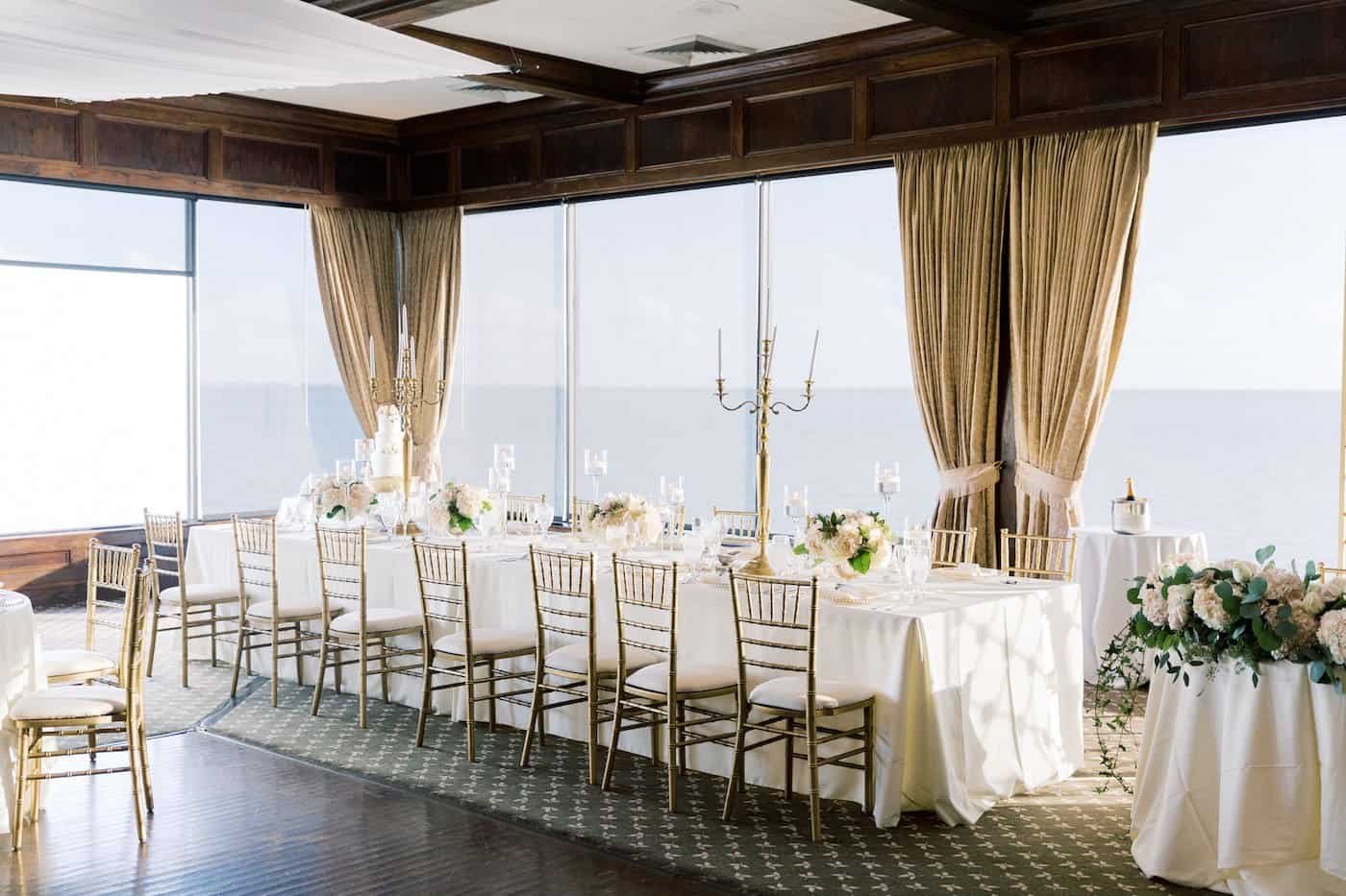 Long Wedding Feasting Table with Gold Chiavari Chairs and Tall Gold Candelabras by Gabro Event Services at The Rusty Pelican