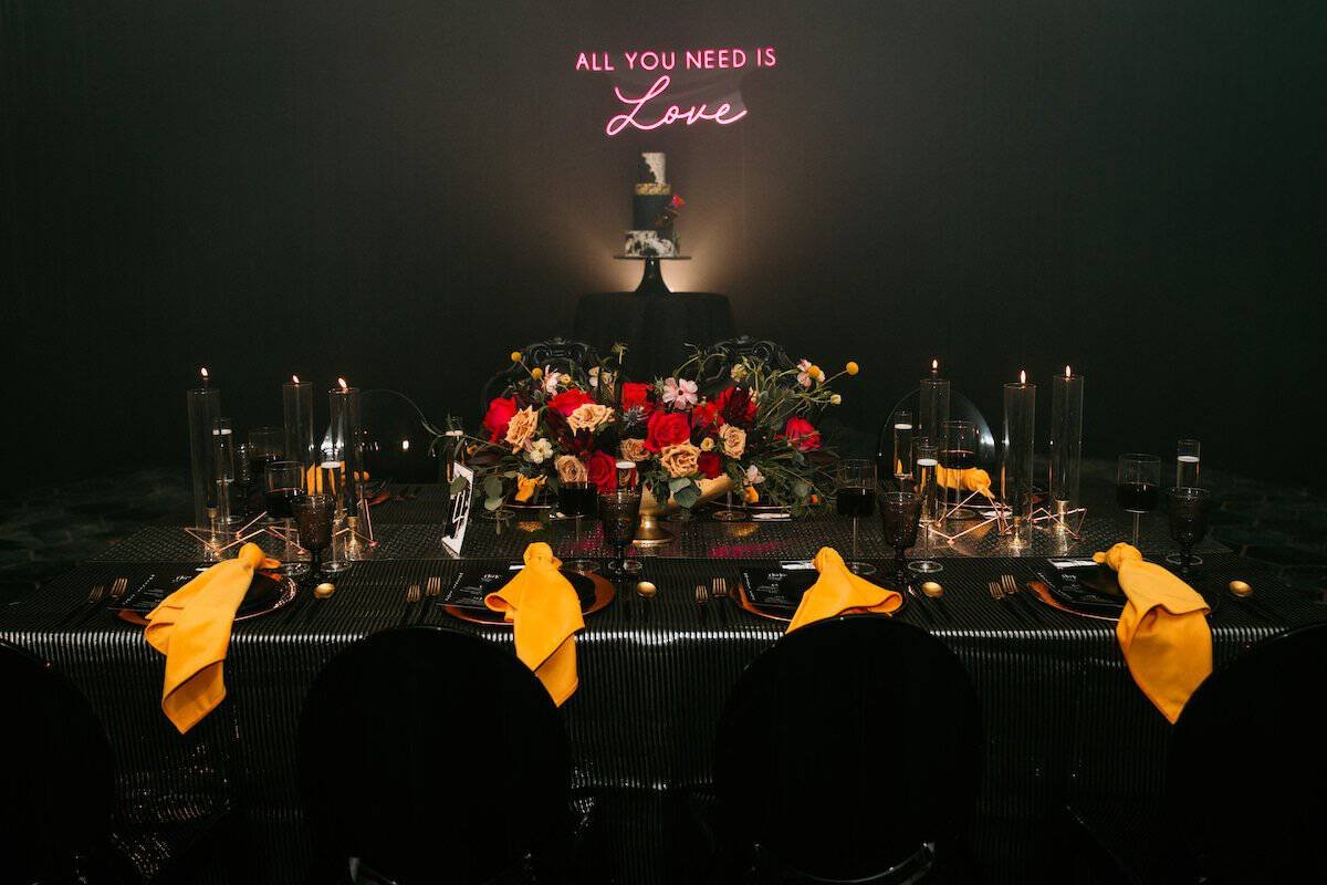 Edgy Modern Reception Table with Textured Linens, Mustard Napkins, Black Candlesticks, and Neon Sign
