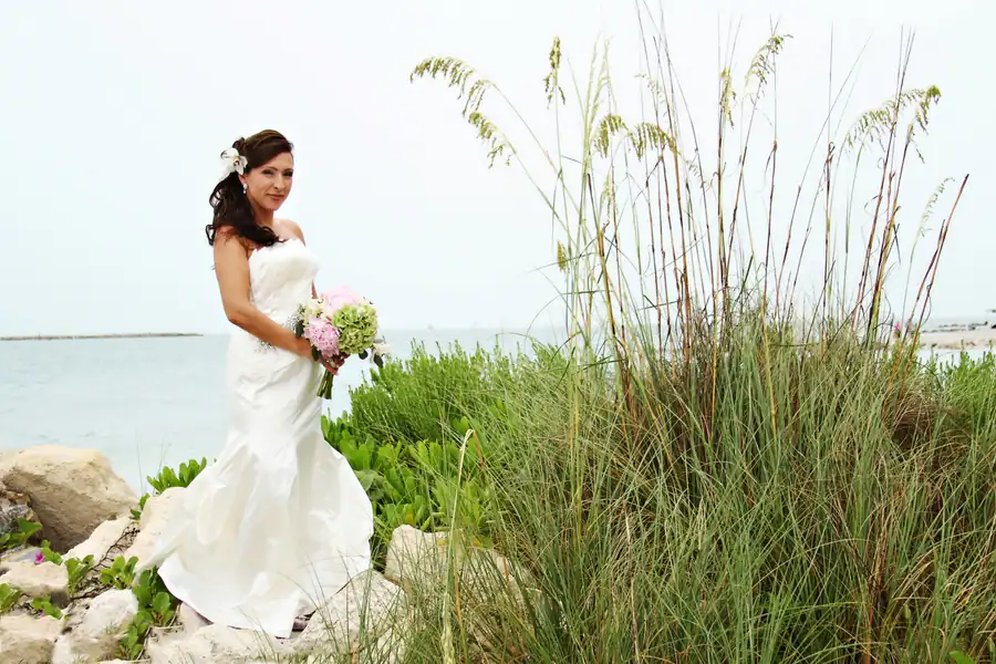 Elegant beach reception tables featuring seafoam green linens and pink floral centerpieces.