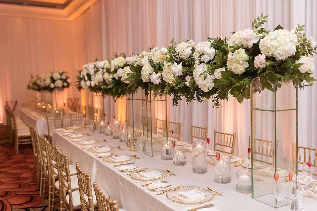 Grand Ballroom Long Feasting Table at Sandpearl Resort with Gold Chiavari Chairs and Tall Floral Vases by Gabro Event Services