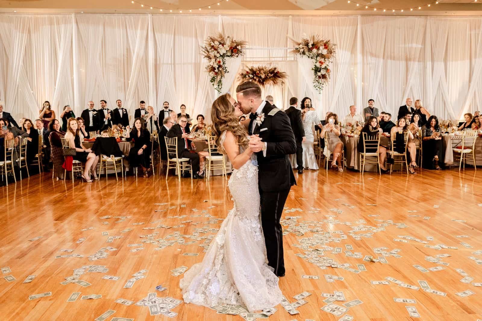 A grand ballroom reception featuring dramatic ceiling draping and glowing bohemian lanterns.