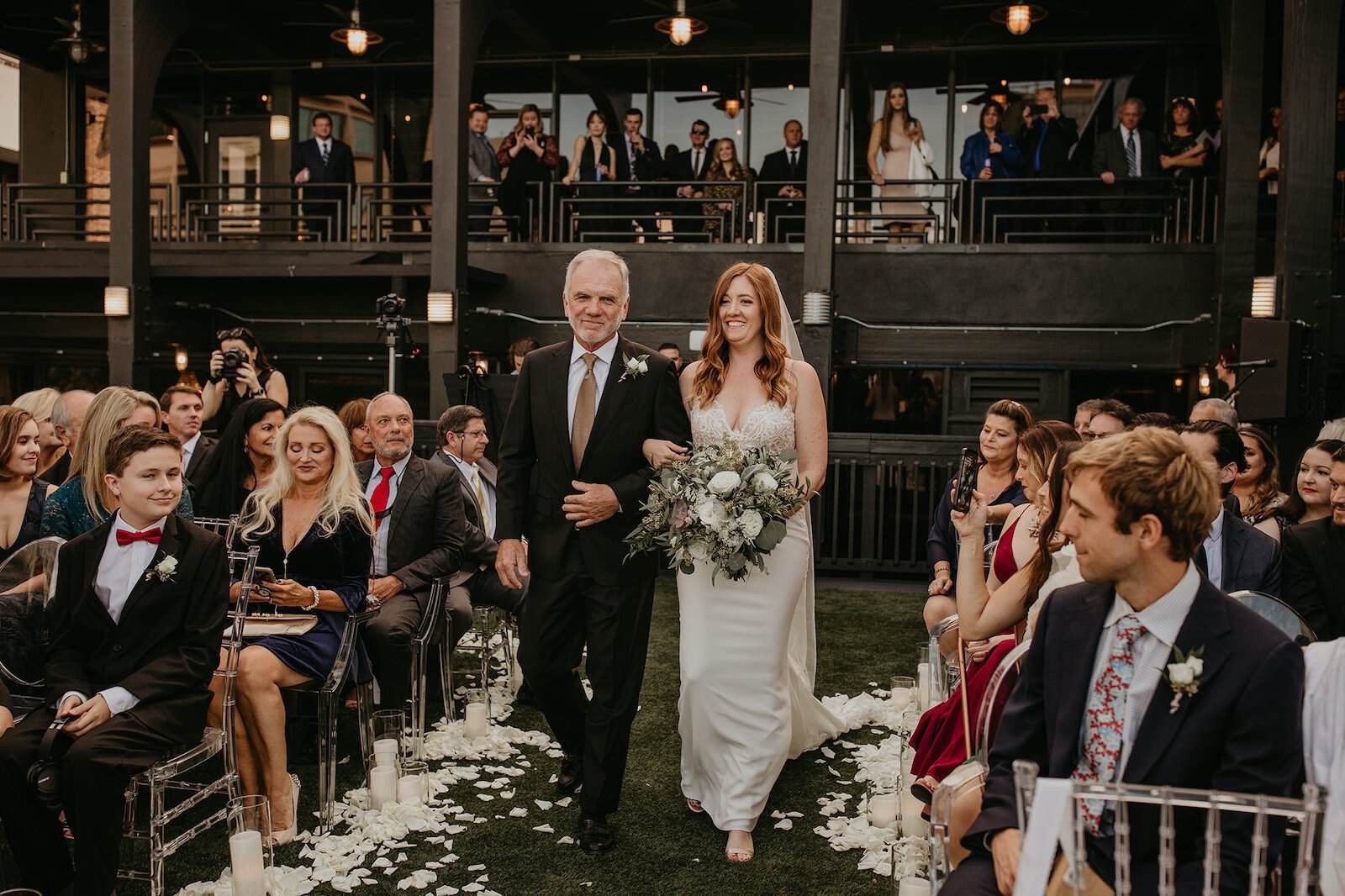 Elegant wedding reception tables decorated with greenery garlands and modern gold accents.