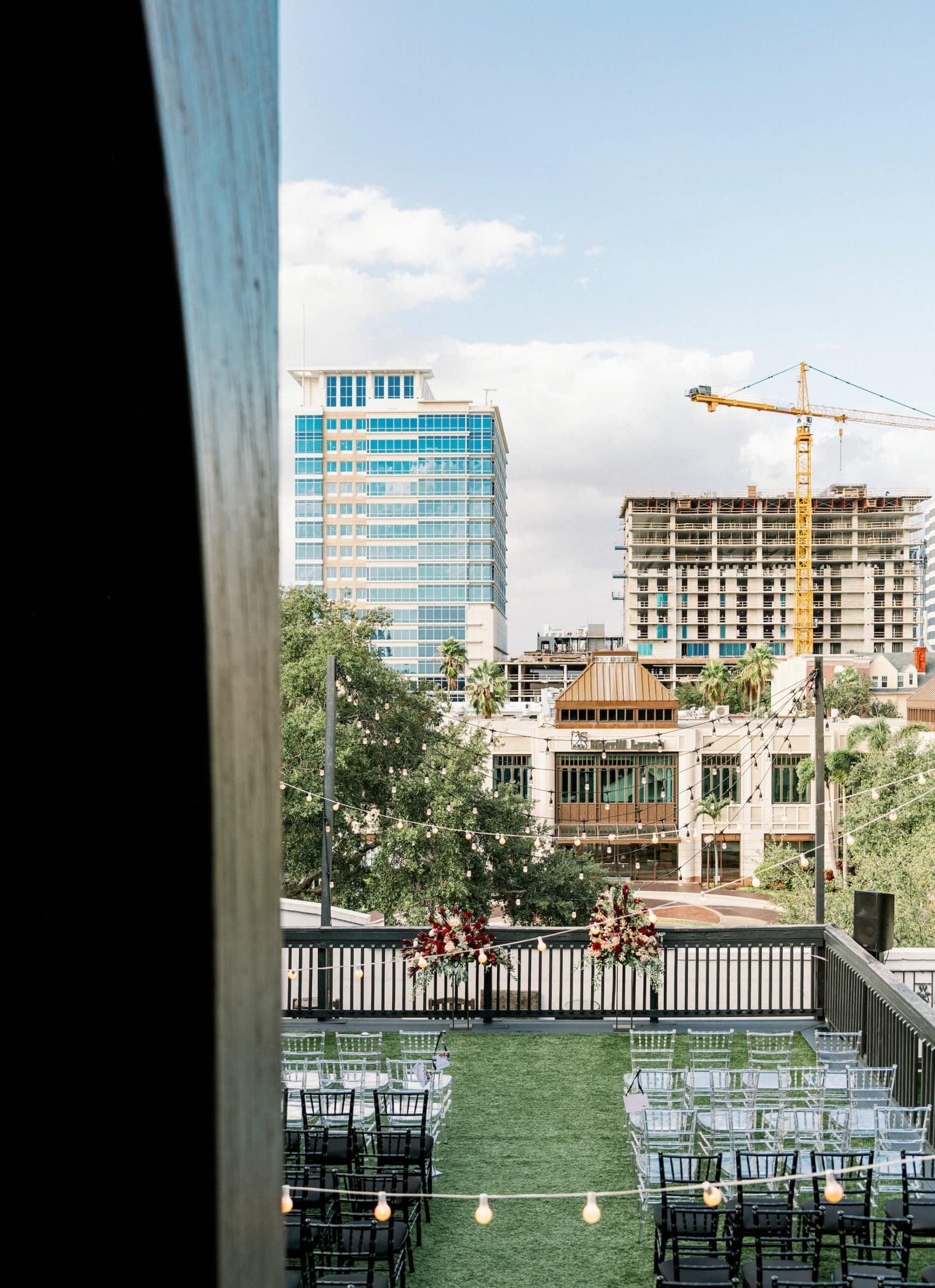 Station House rooftop wedding ceremony with onyx black chiavari chairs and brick skyline views