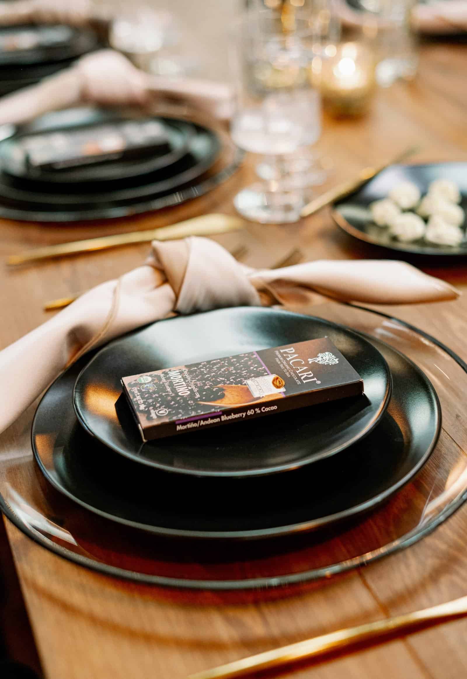 Dramatic black charger plates with modern acrylic table numbers and gold flatware