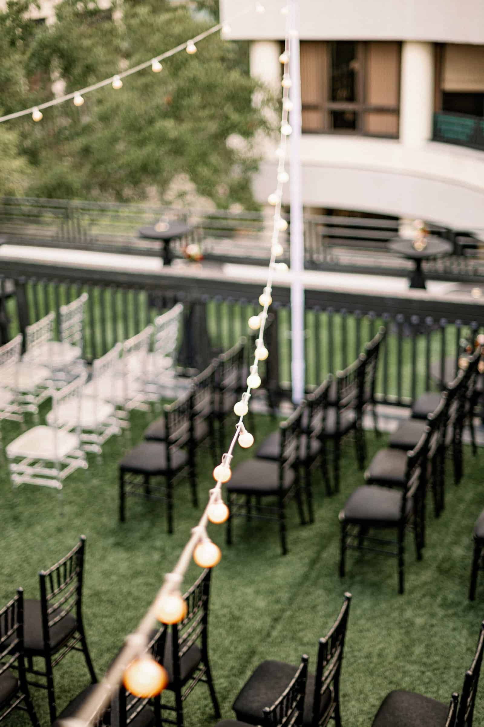 Rows of black Chiavari chairs set on the rooftop lawn at Station House in Downtown St. Pete