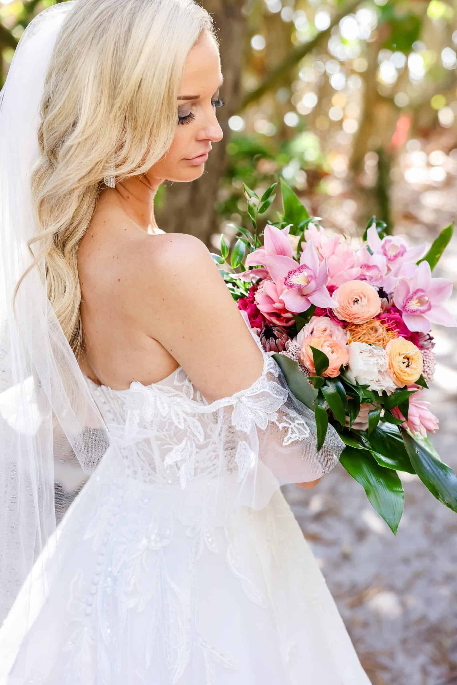 Beachy Bride Holding Vibrant Tropical Floral Bouquet with Sunset Orange and Pink Blooms