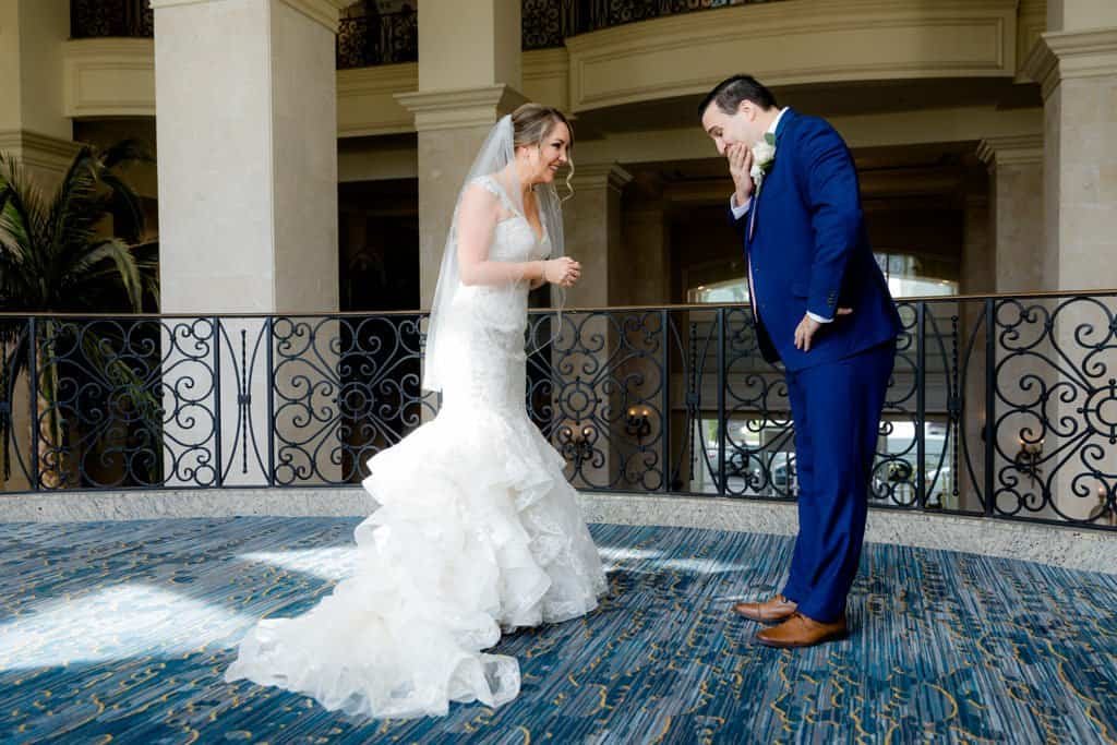 A decorated wedding reception table featuring navy linens and shimmering gold accents.
