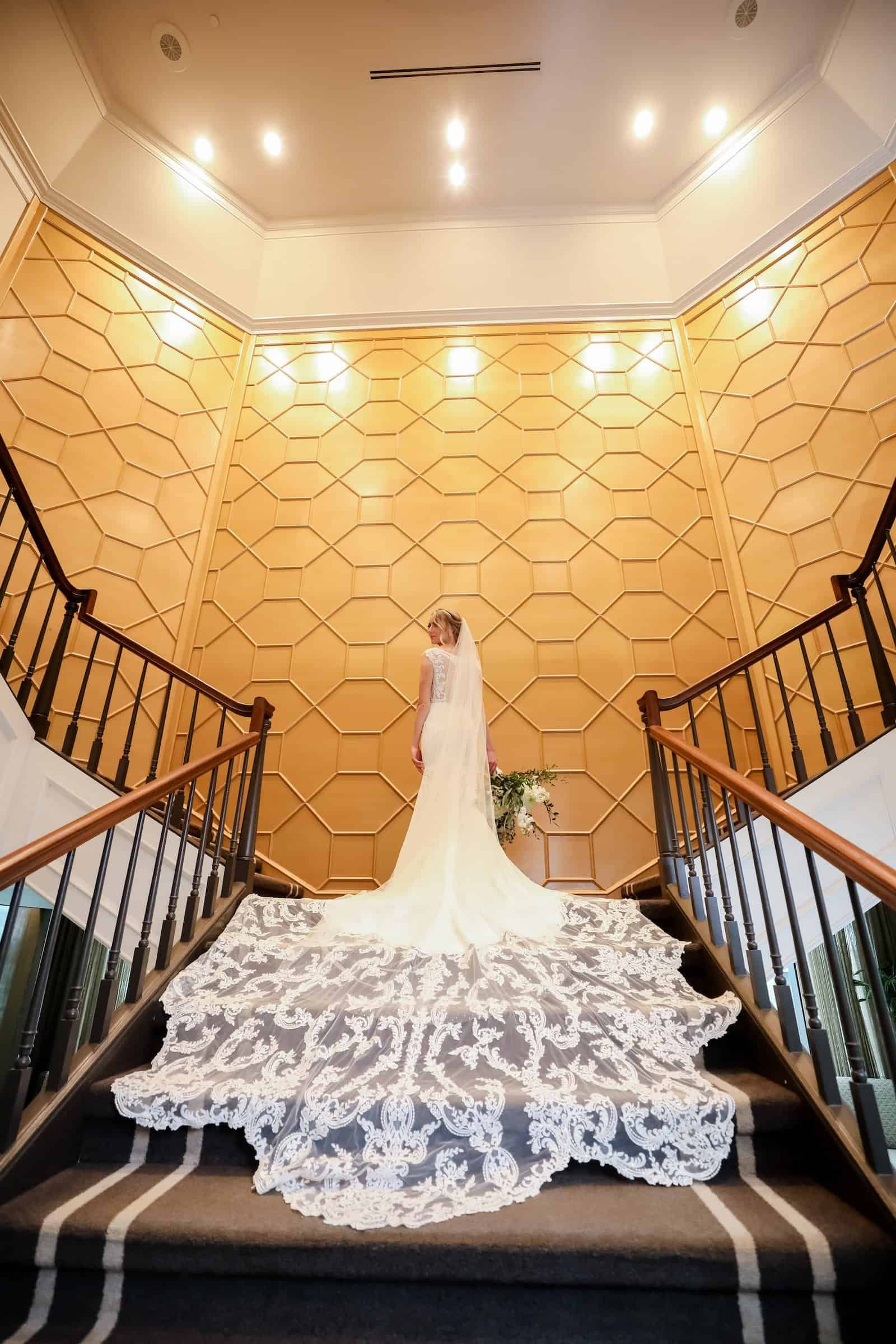 Grand Ballroom at Tampa Marriott Water Street Featuring Pink Uplighting, White Drapes, and Gold Chiavari Chairs