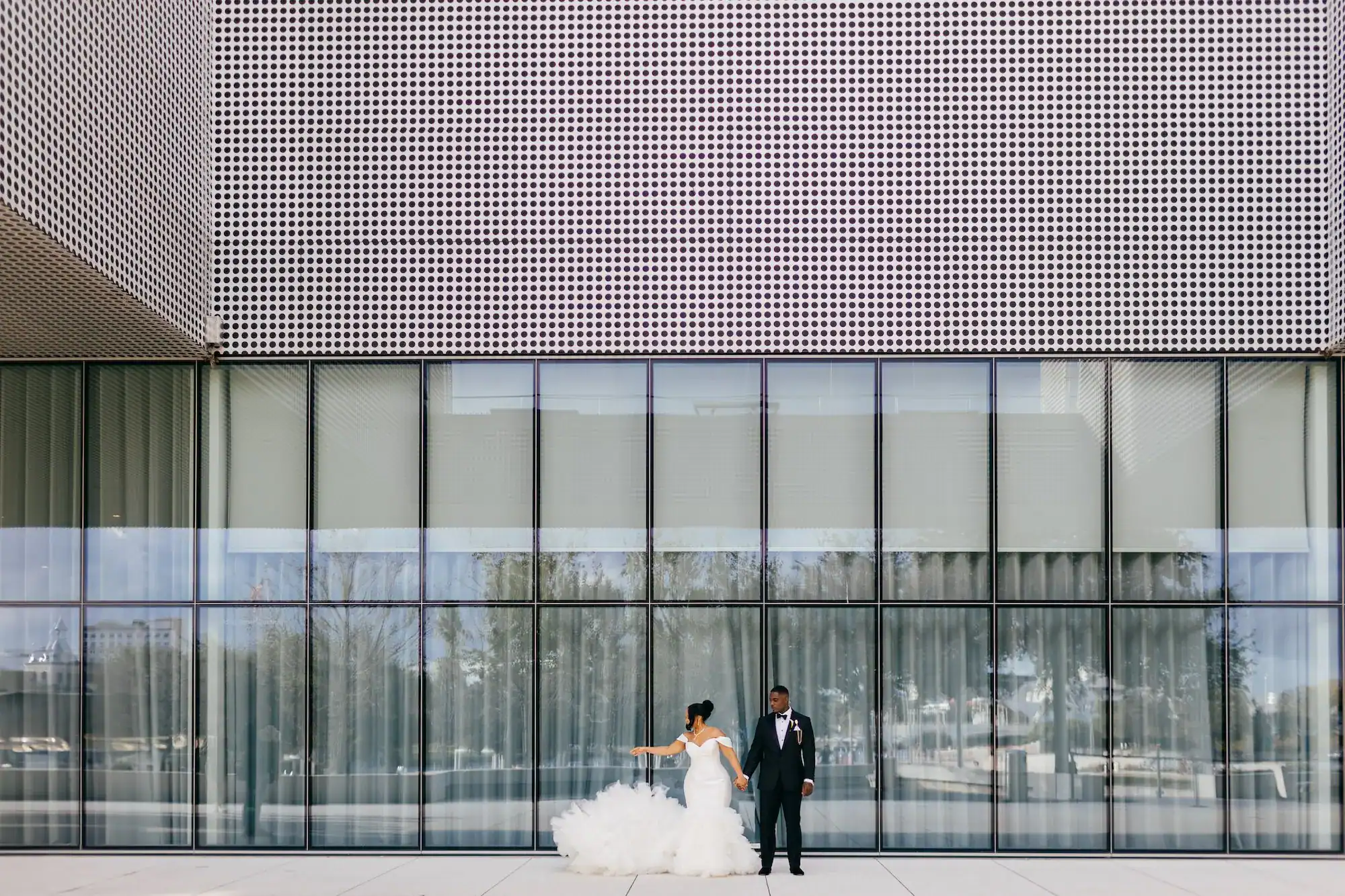 A reception table set with black chargers and white lilies in a museum.