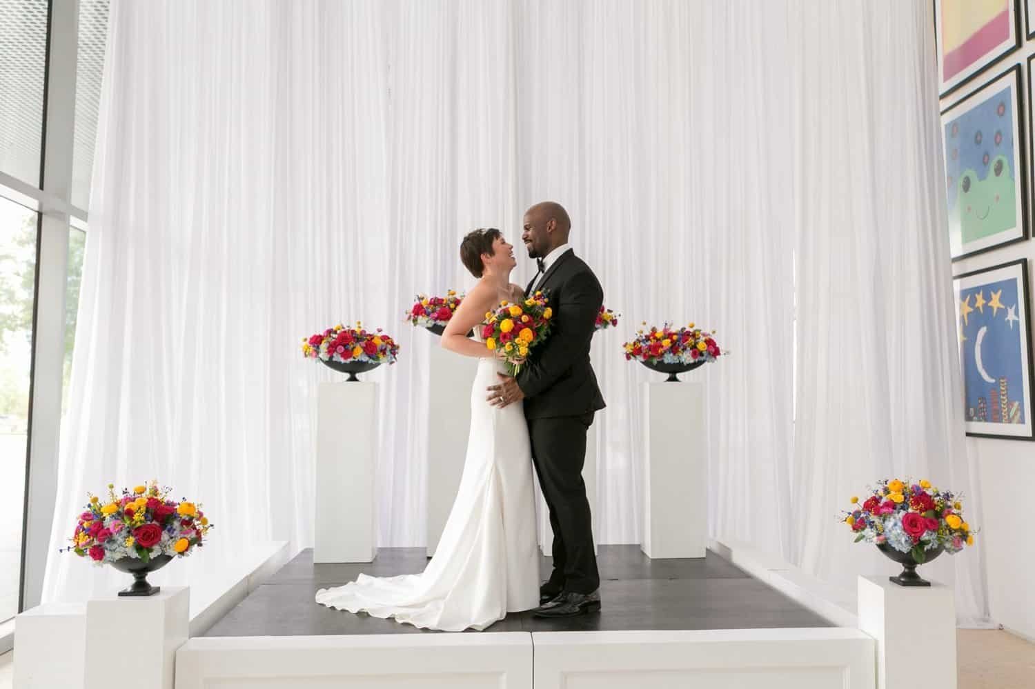 Covered terrace waterfront wedding ceremony at Tampa Museum of Art featuring clear acrylic ghost chairs by Gabro Event Services