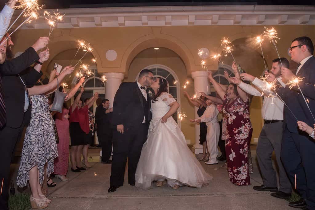 A couple sharing their first dance in a classic ballroom with elegant lighting.