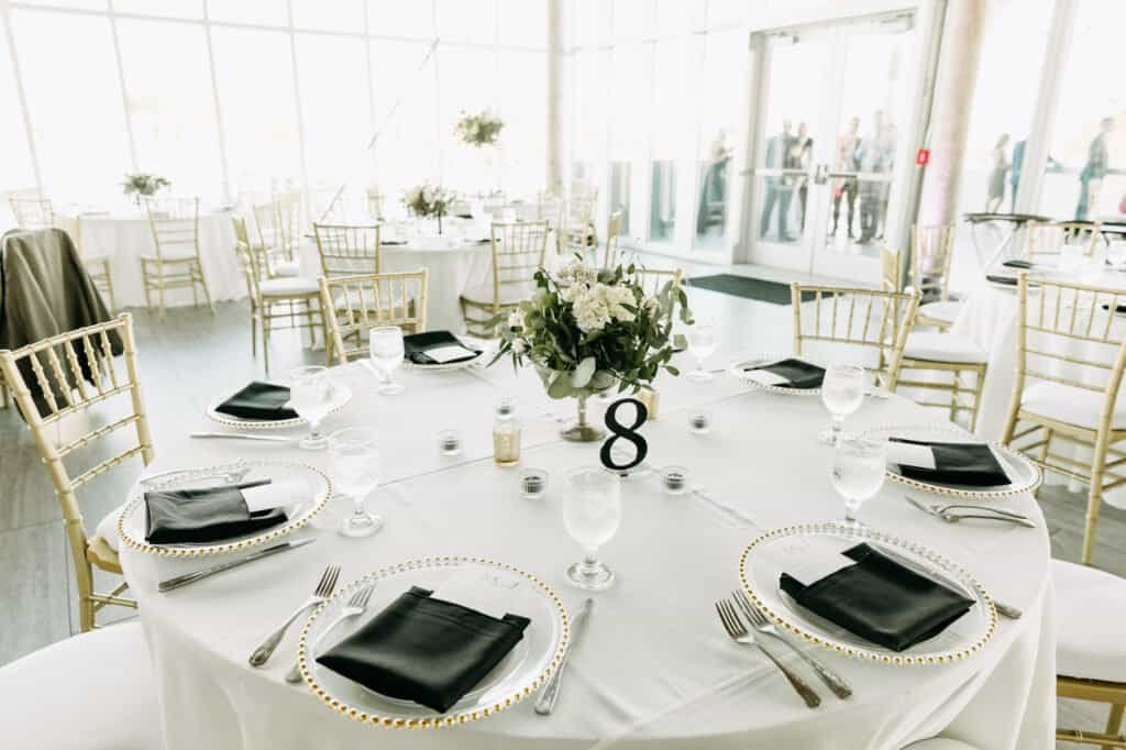 Round table at the Tampa River Center with gold chargers, black napkins and gold Chiavari chairs