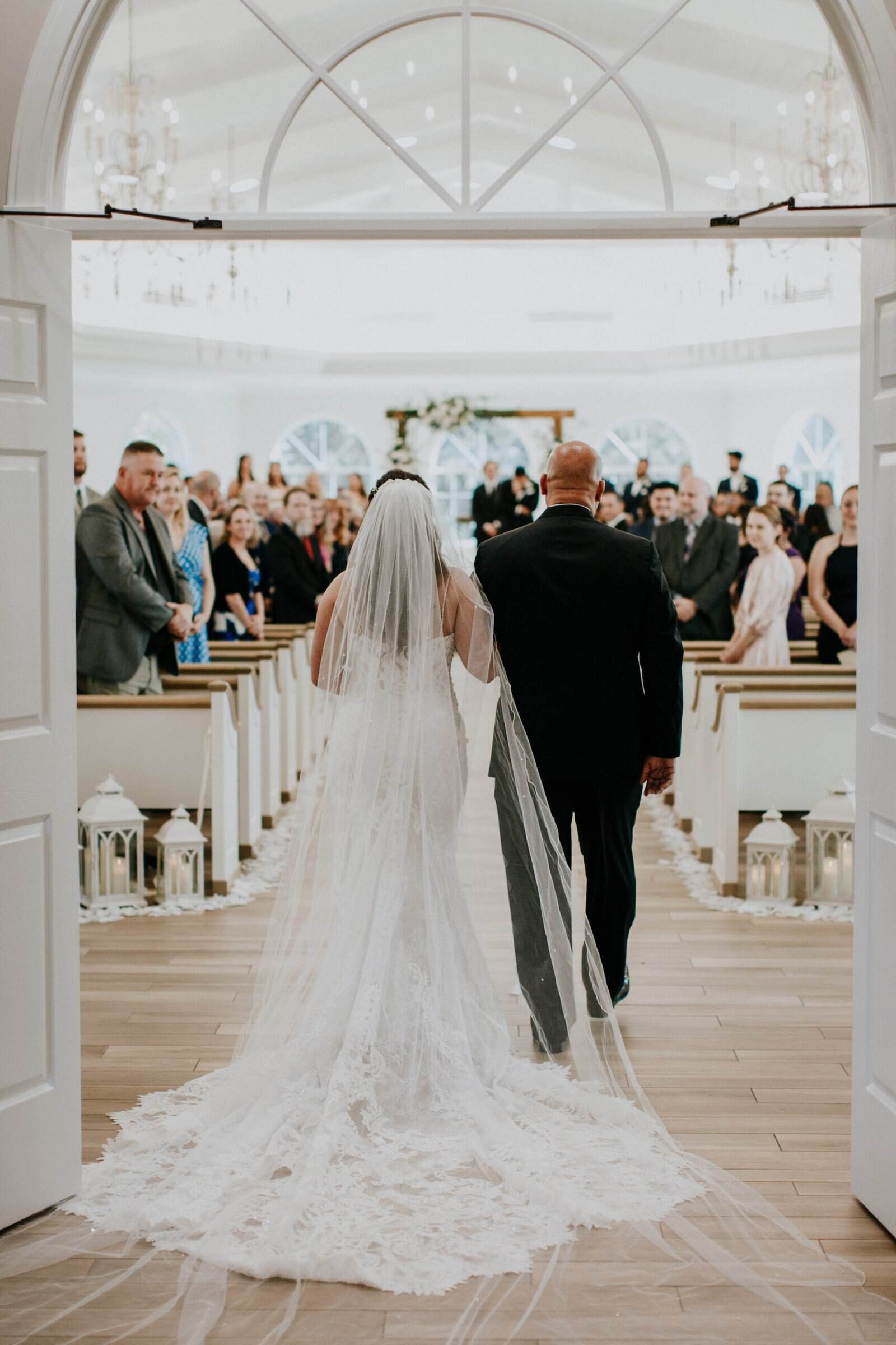 Guests dancing on a high-gloss floor under warm ballroom lighting at night.