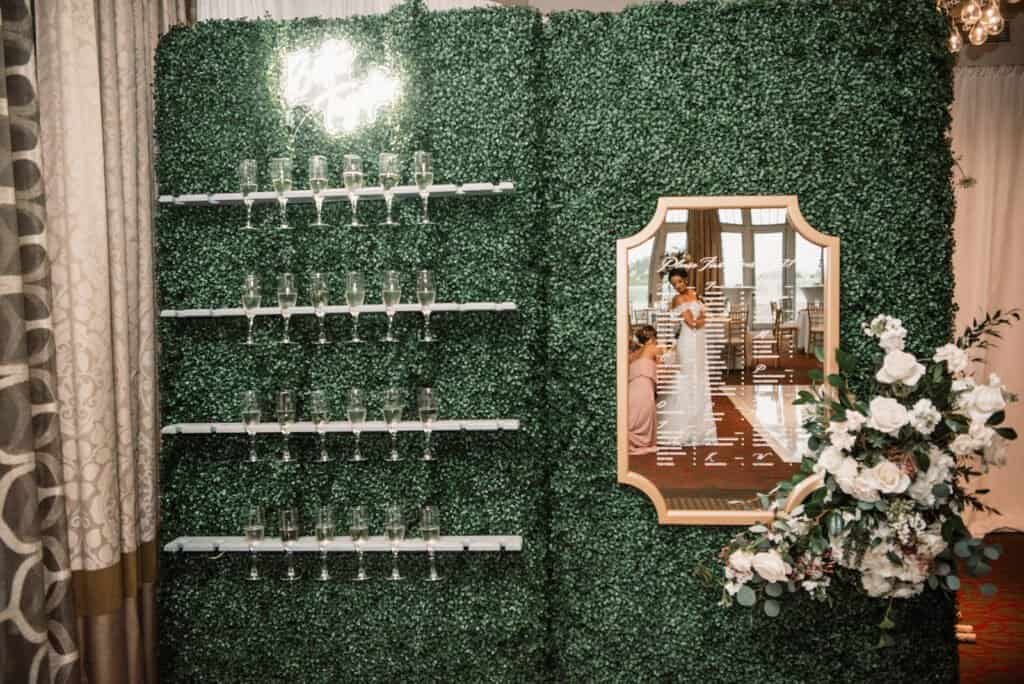 Custom green boxwood hedge wall backdrop and gold mirrors at The Birchwood