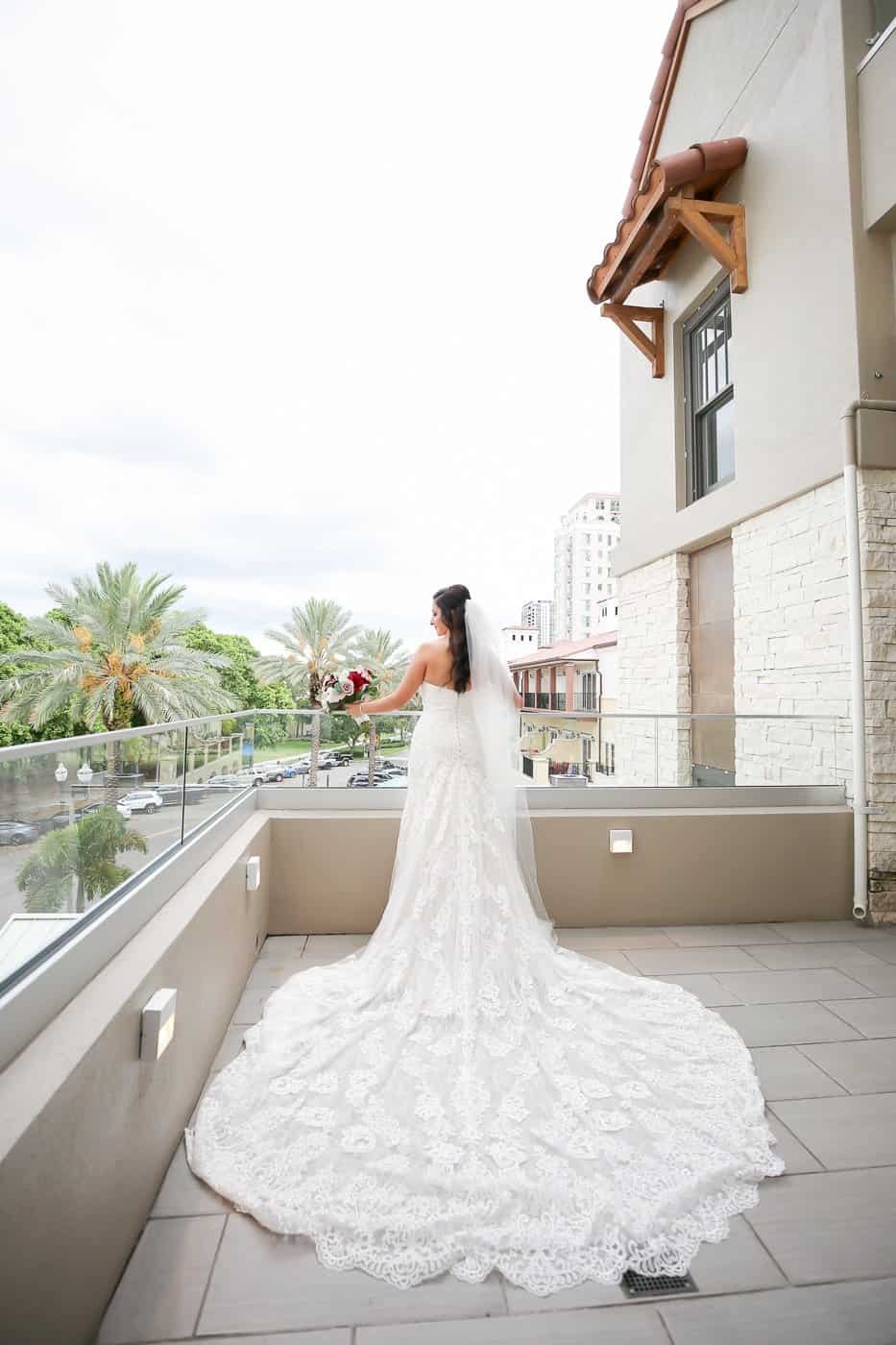 Romantic bridal portrait in lace gown on The Birchwood hotel balcony overlooking Beach Drive in Downtown St. Petersburg