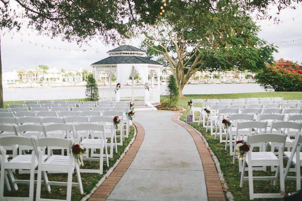 Bride and groom sharing their romantic first dance surrounded by gold chairs, floral displays, and amber ballroom uplighting