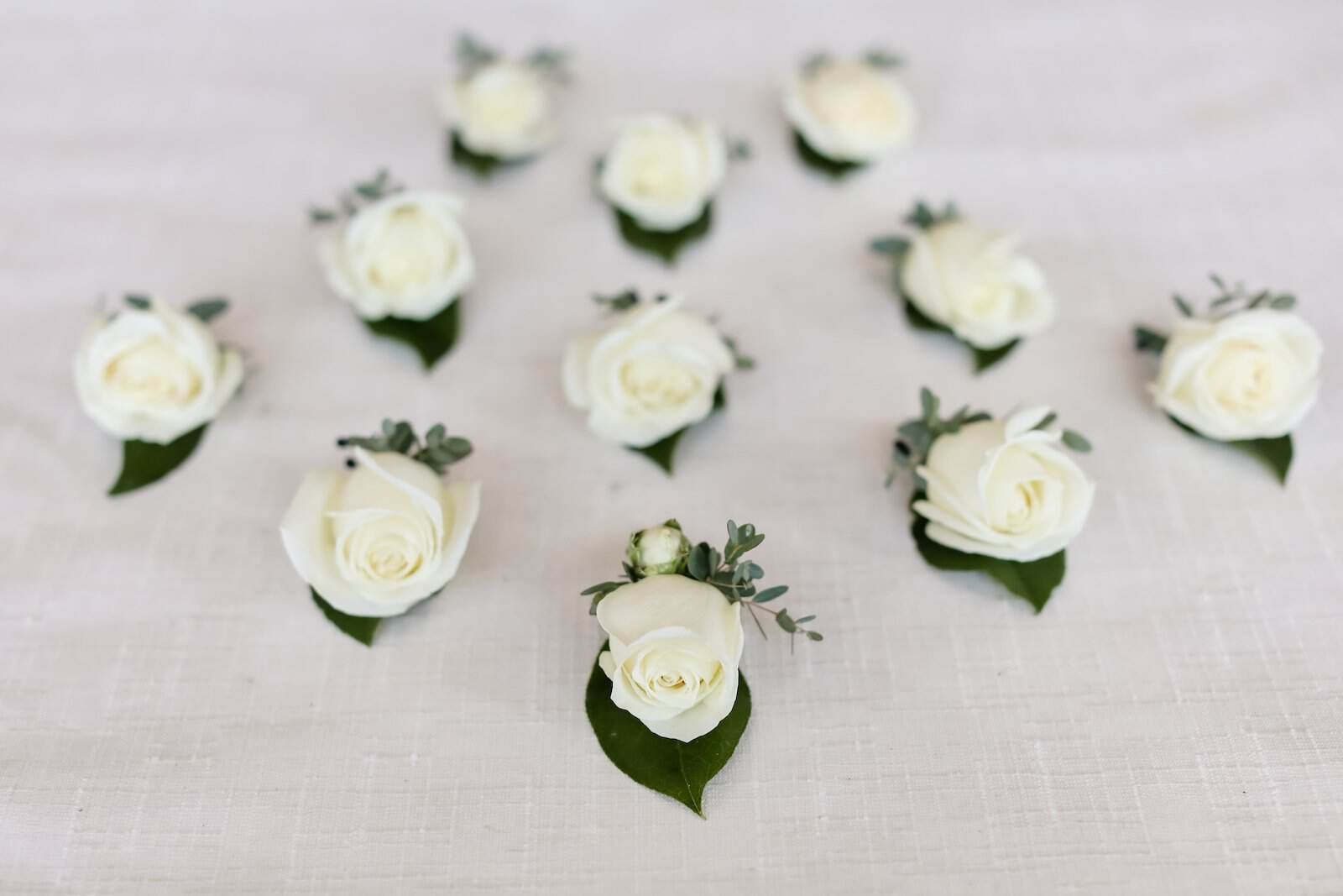 A sophisticated white and gold outdoor ceremony setup on the Clearwater beach sand.