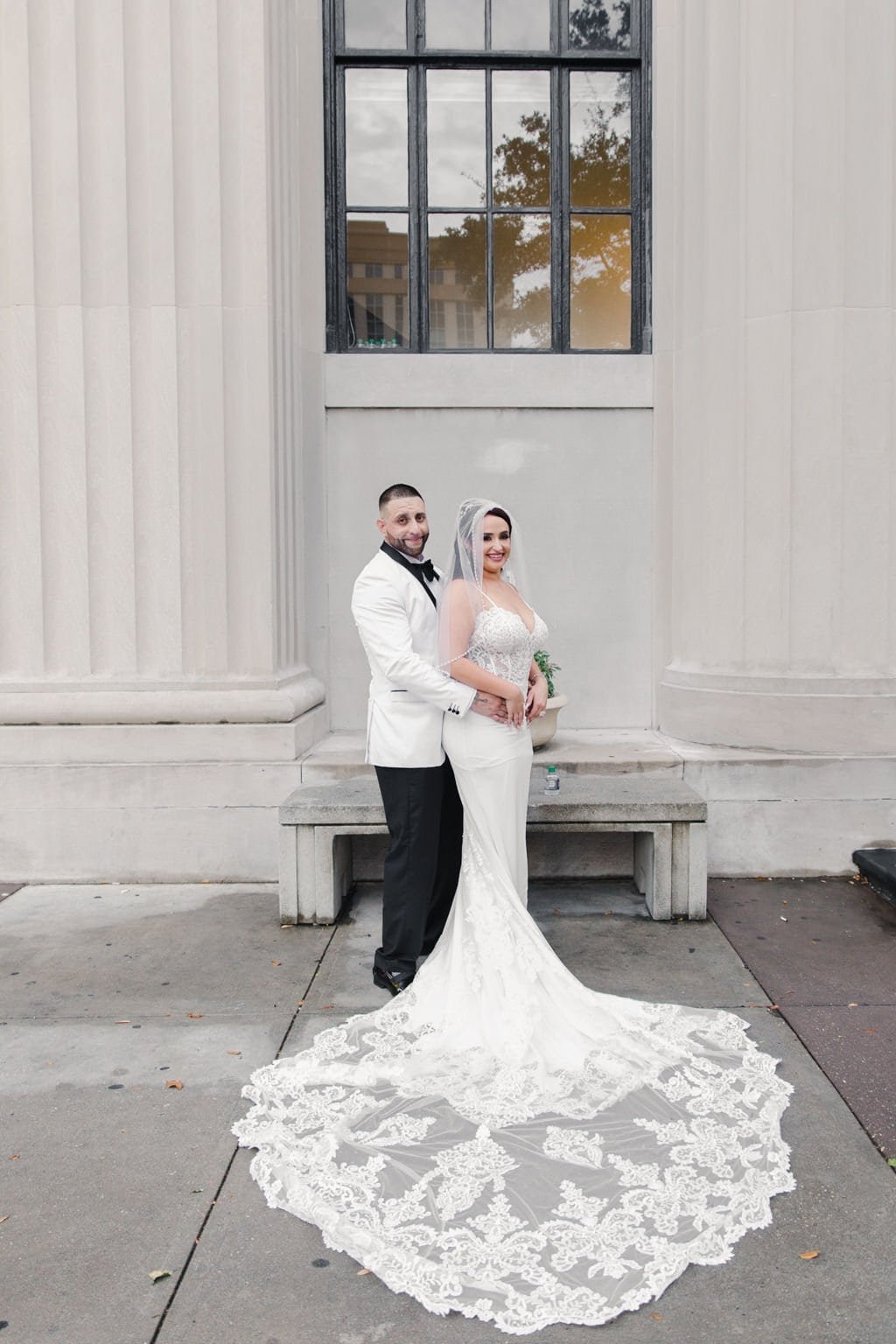 Bride in Lace Gown and Groom in White Tuxedo Romantic Wedding Portrait by Carography Studios