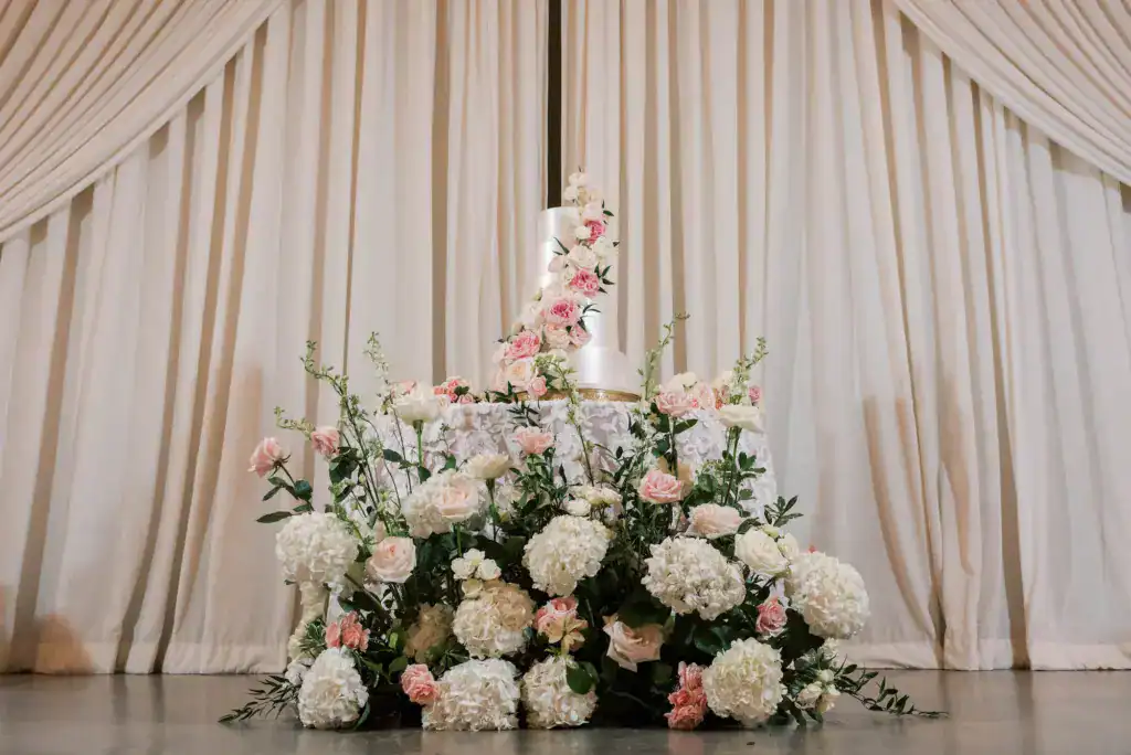 Cake table set against a full-height ivory drape wall at The Vinoy