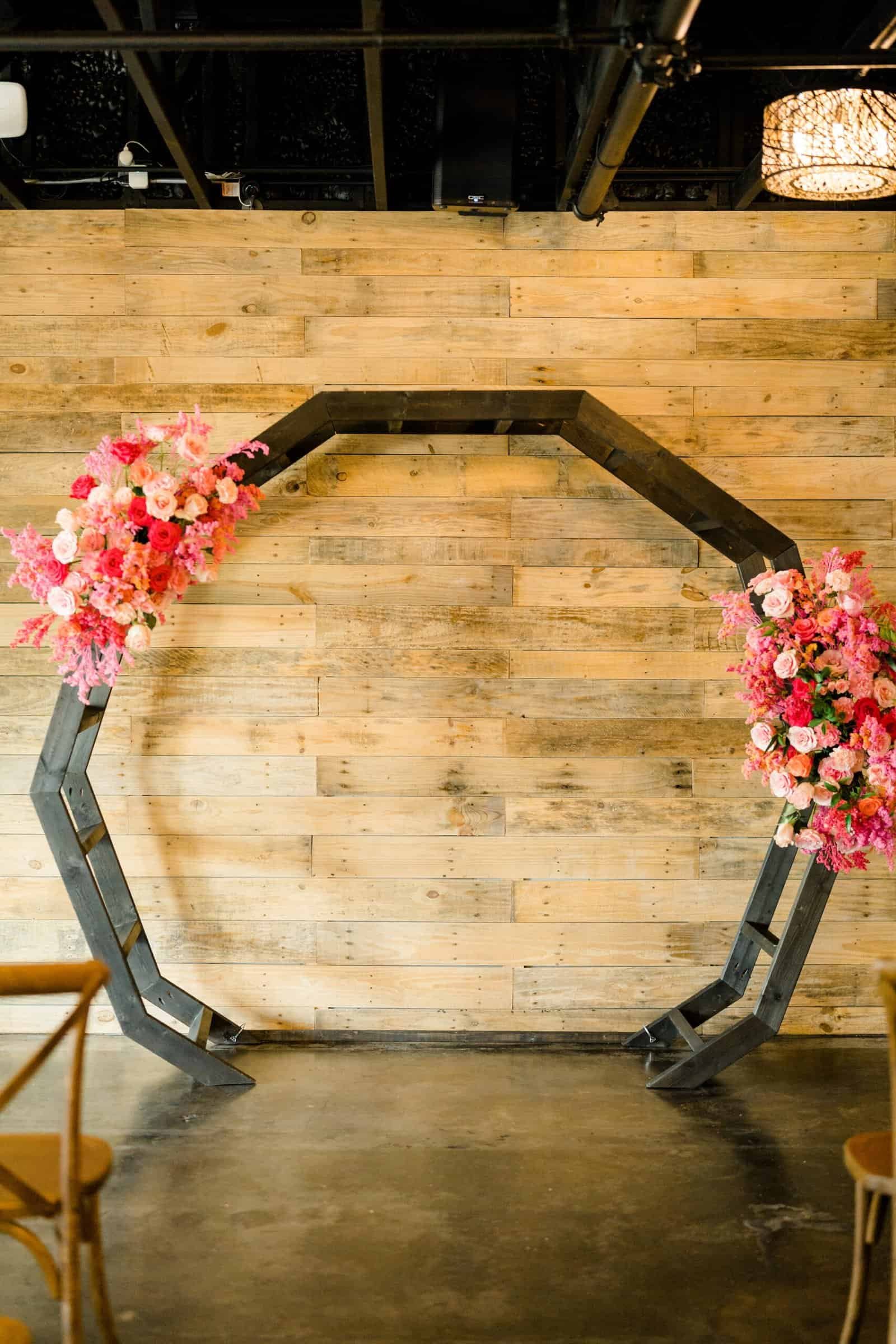 Vibrant fuchsia floral arrangements and turquoise stationery set against a clean white wedding backdrop.
