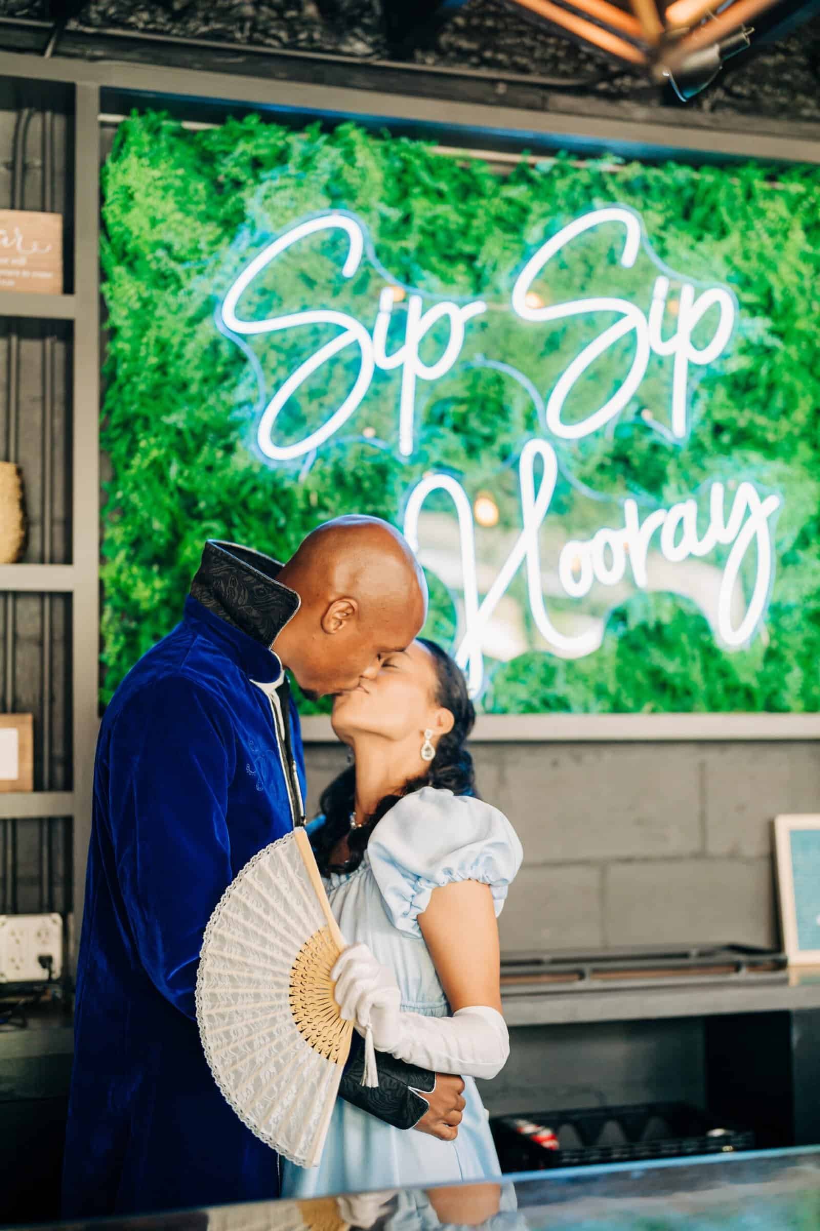 Living green hedge backdrop with a neon script sign at The West Events