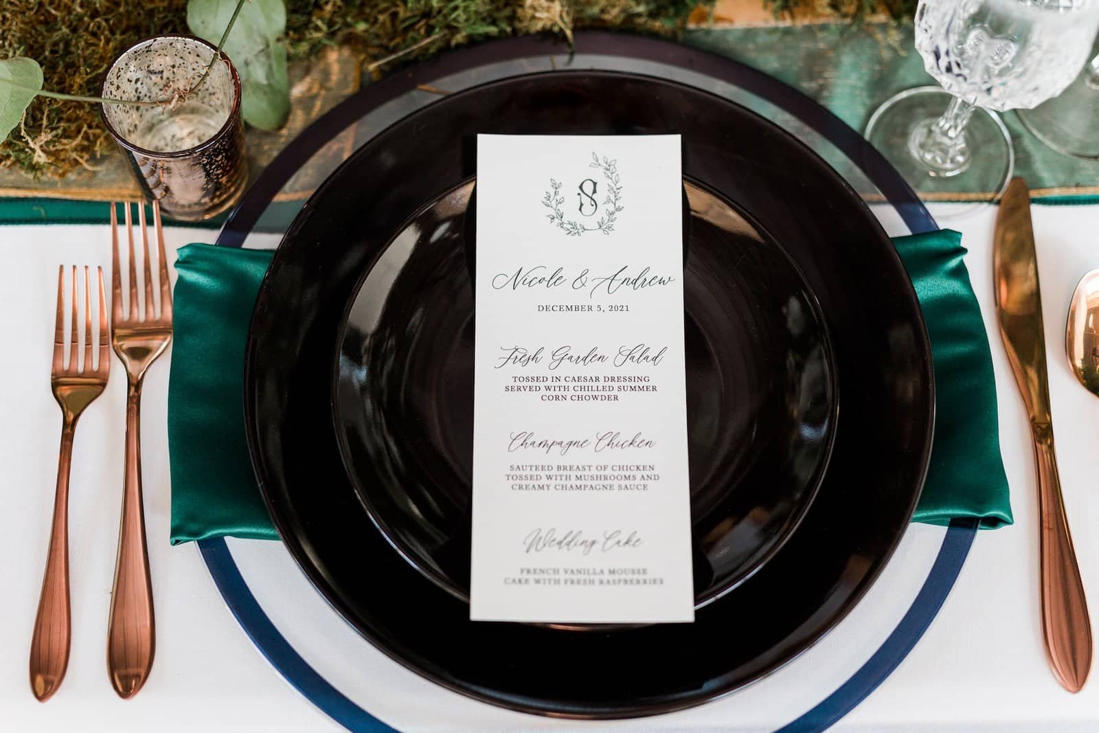 Place setting with an emerald green velvet napkin folded on white linen