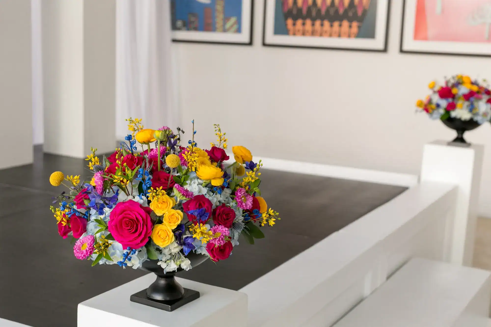 Vibrant yellow, pink, and blue floral ceremony altar installations framing the riverfront