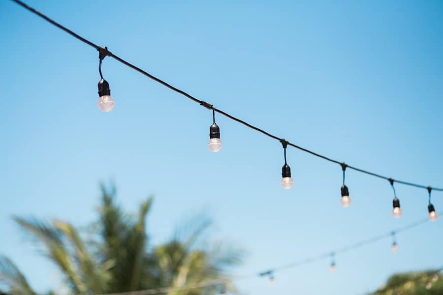 Warm Edison Bulb Market String Lighting by Gabro Event Services Over Outdoor Deck