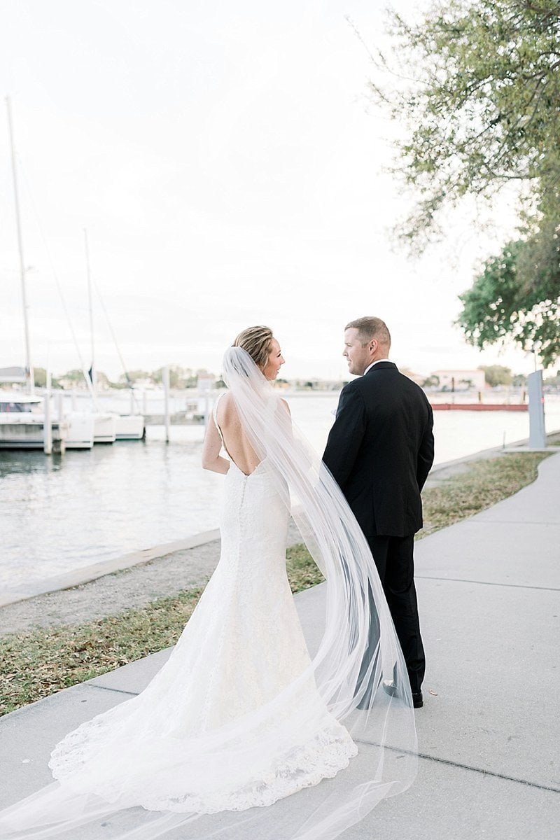 Newlyweds dancing beneath grand crystal chandeliers and glowing ambient lighting during their evening reception