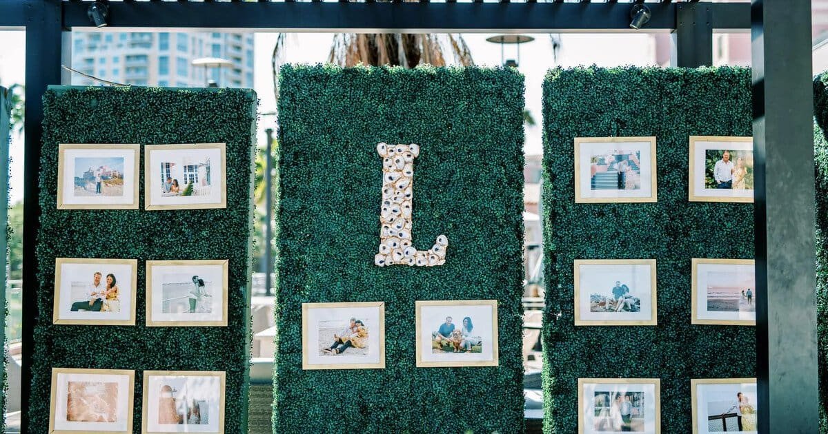 Green privacy hedge wall used as a photo backdrop with custom oyster shell initials