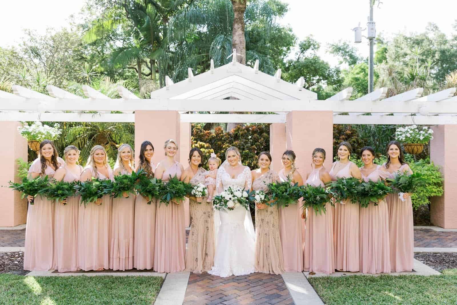 Bride in Long-Sleeve Illusion Lace Gown with Bridesmaids in Emerald and Blush at Vinoy Courtyard