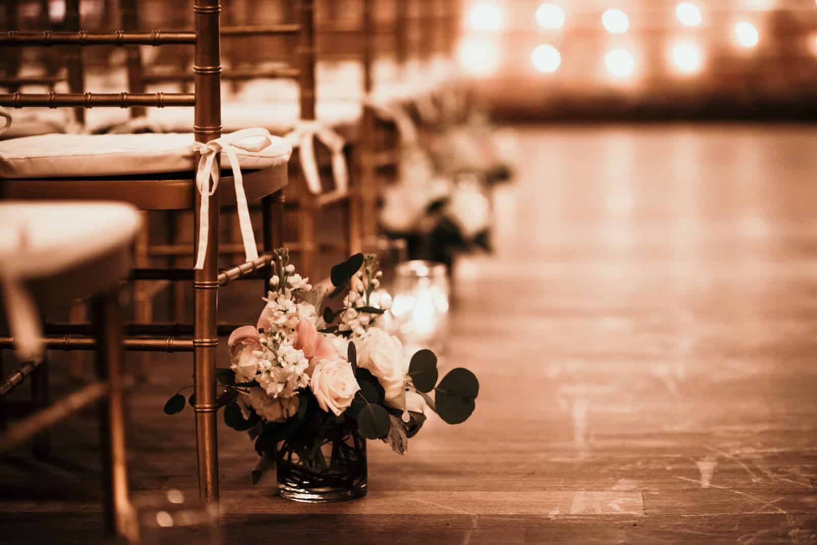 Taylor and Darian exchanging vows in front of arched historic windows with lush red and burgundy floral arches at The Vinoy Renaissance