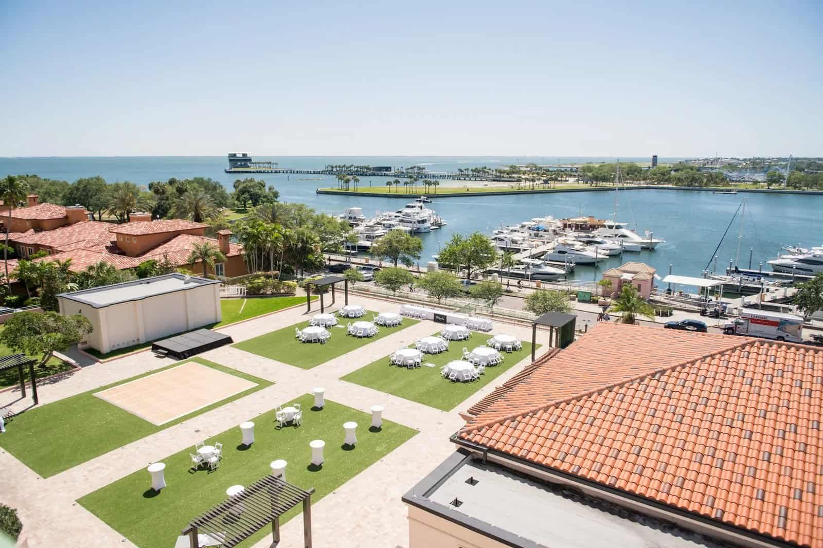 Aerial view of an outdoor wedding reception laid out on the lawn at The Vinoy overlooking the marina