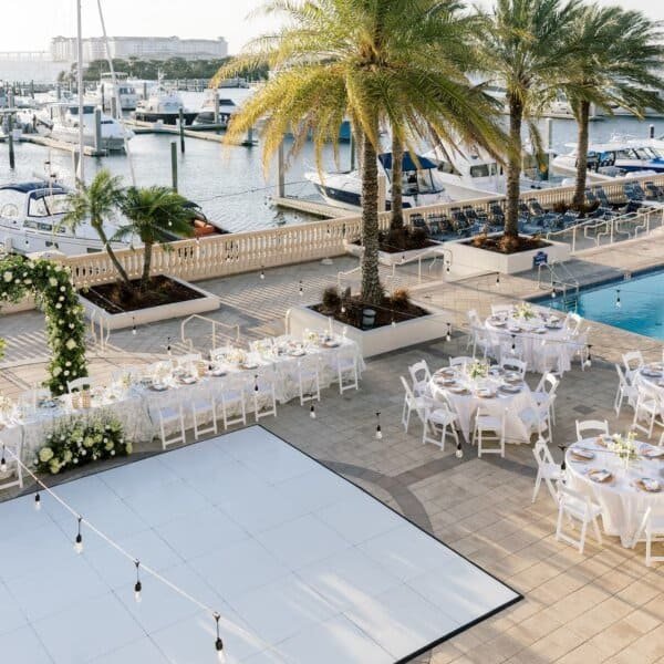 Poolside terrace ceremony seating and modern floral staging at Hotel Alba