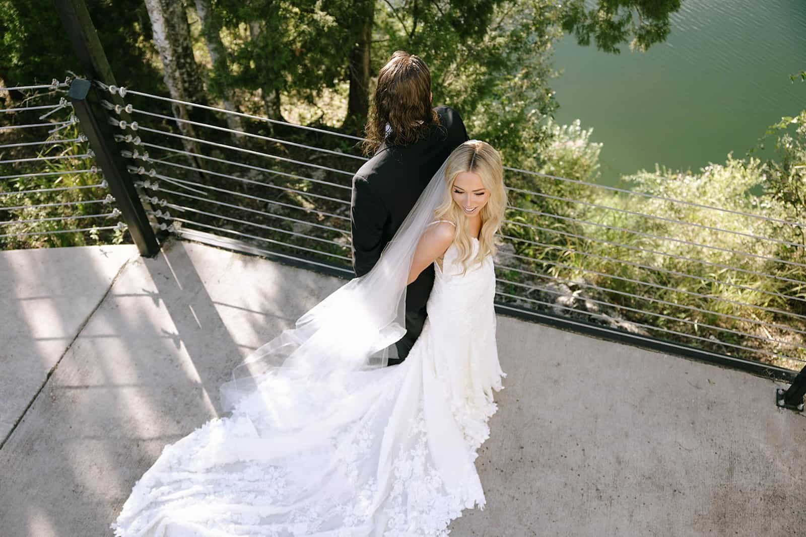 The happy couple standing together in their custom modern wedding day attire.