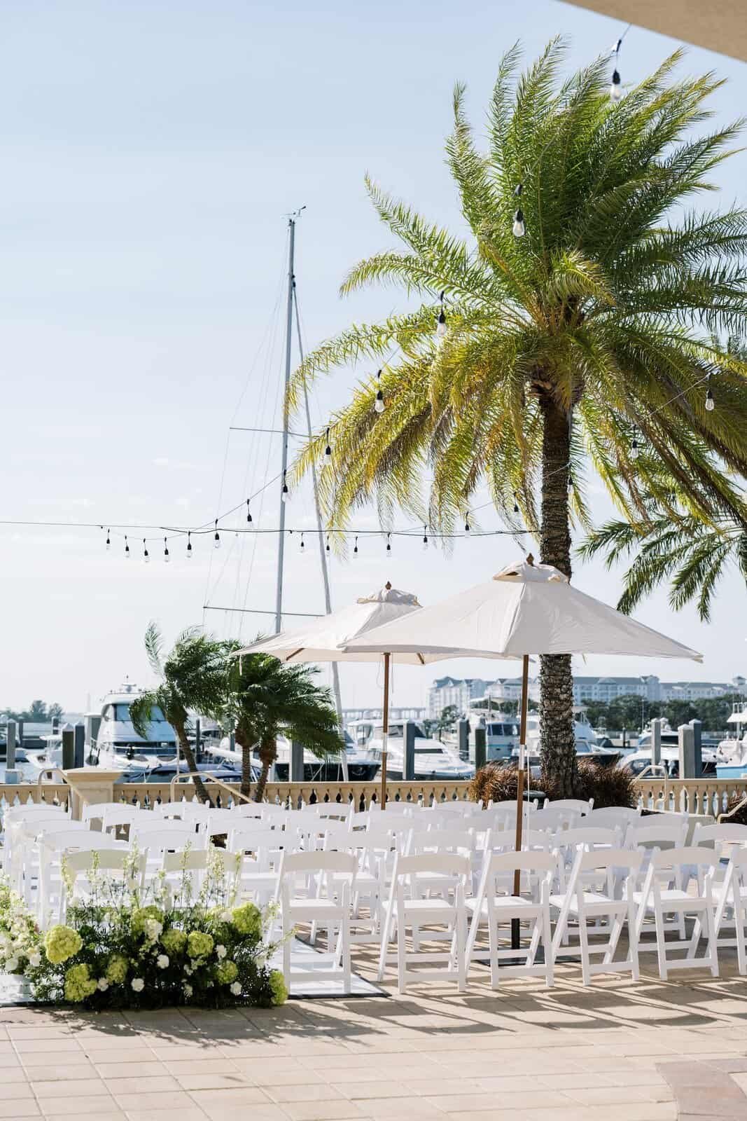 White umbrellas shading the waterfront deck at Westshore Yacht Club before a wedding ceremony