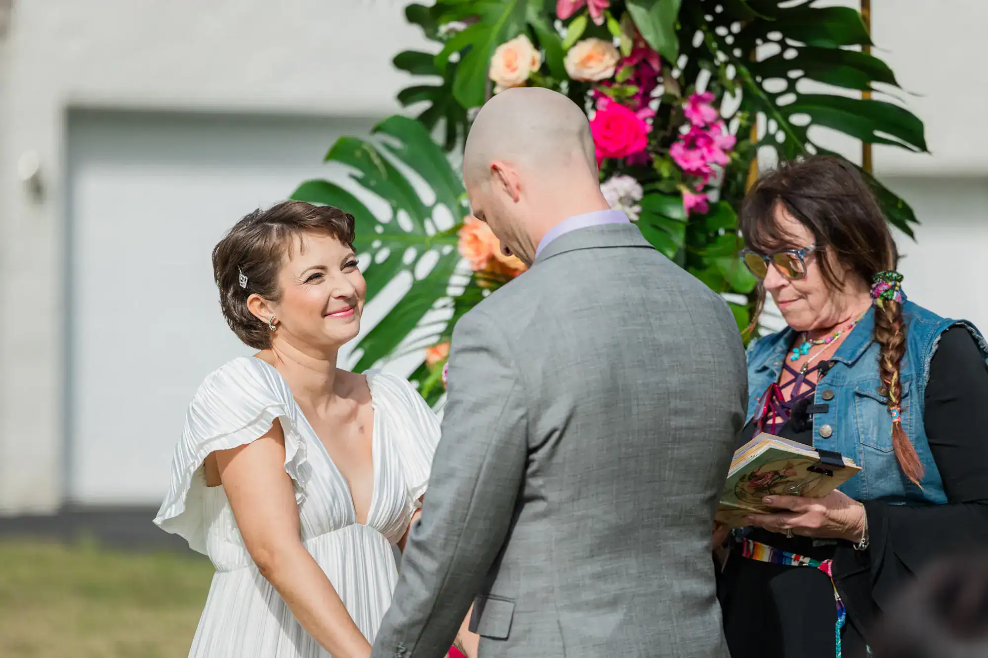 A joyful couple dancing at their tropical-themed reception under elegant event lighting.