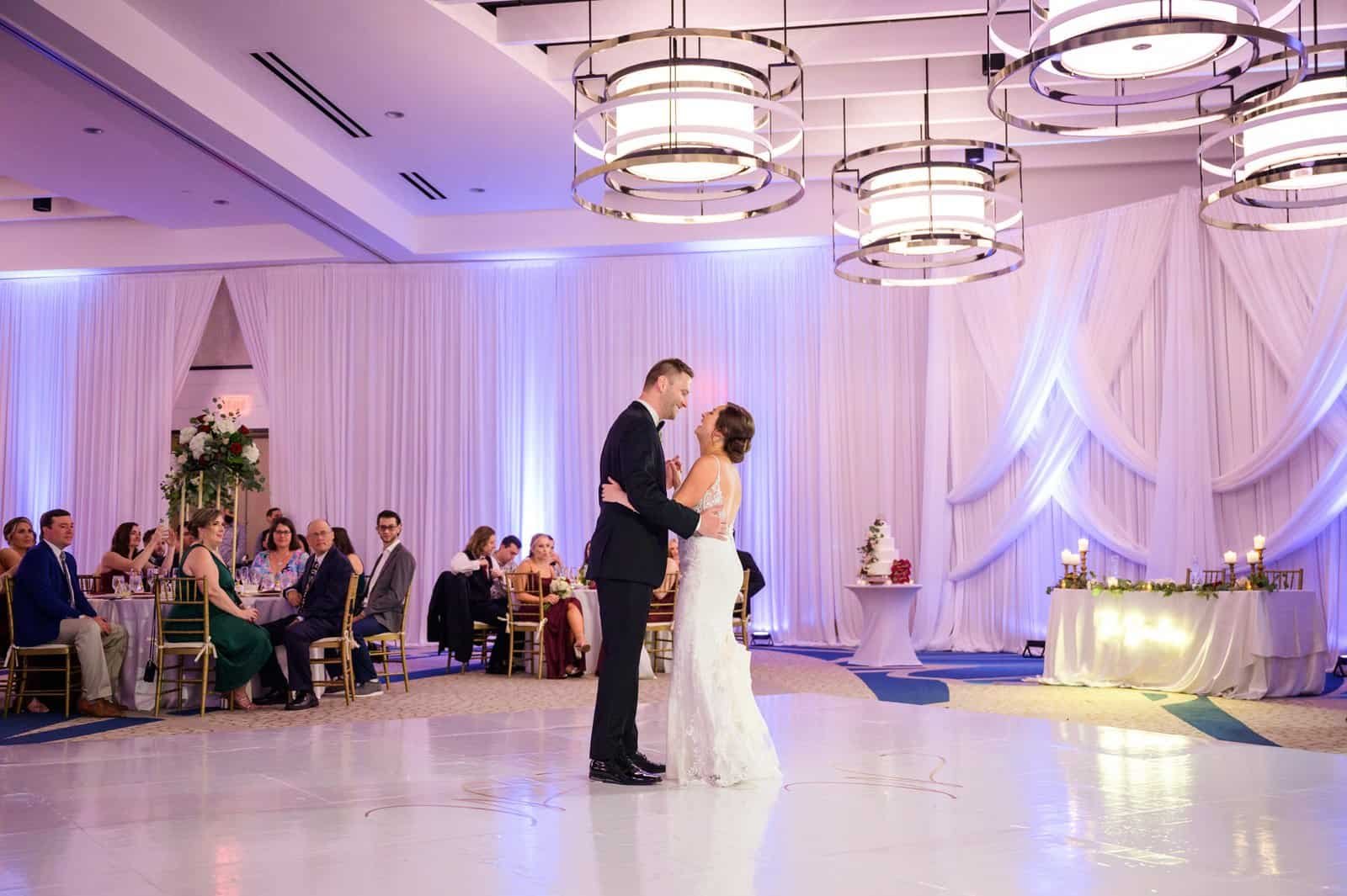 First dance on the white dance floor with full-height draping behind at the Wyndham Grand Clearwater Beach