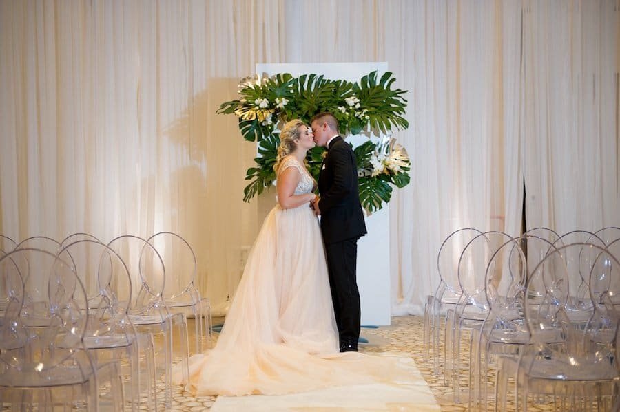 Lavish gold ballroom tablescape featuring gold chiavari chairs, metallic chargers, and cascading floral runner